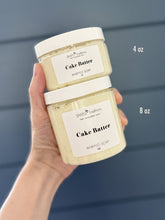 Hand holding two jars of 'Cake Batter' whipped soap with labels and measurements.