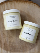 Two containers of 'Cake Batter' products on a wooden surface