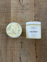 Two containers of 'Cake Batter' whipped soap on a wooden surface