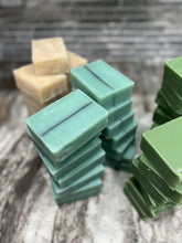 Stacks of green and beige soap bars on a textured surface